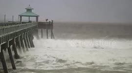 Surfers jump off Florida pier during Hurricane Matthew