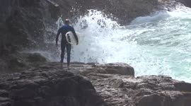 Crazy surfer risks his life in rough seas