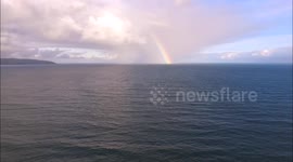 Drone footage of a rainbow out at sea