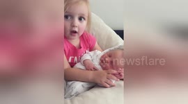 Toddler sings song to her newborn sister