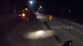Biker crashes into car doing a U-turn