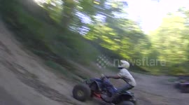 Quad biker attempts steep ascent and fails badly