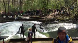 Surfers ride waves on river in Munich