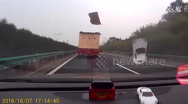 Debris flies out of trailer and smashes windscreen of car behind