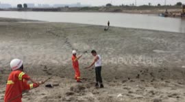 Firefighters rescue an elderly man trapped in wet sand