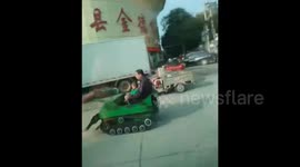 Man and grandson drive toy tank on road