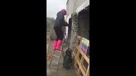 Girl pressure washing old stone wall wearing pink for #loowithaview conversion cornwall