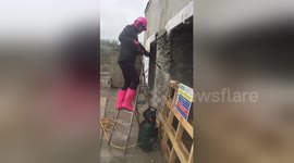 Newsflare Edit - Girl pressure washing old stone wall wearing pink for #loowithaview conversion cornwall