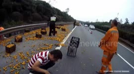Villagers grab oranges drop from a lorry turning over on motorway