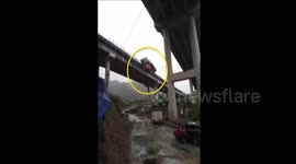 Out-of-control trailer hangs off the edge of a bridge