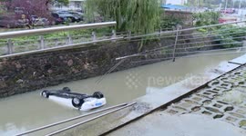 泰州:倒车太快汽车落水 隔壁保安紧急救援