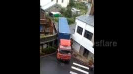 Lorry squeezes through narrow gap between houses