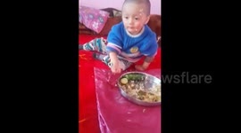 Tired toddler falls asleep while eating rice