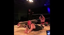 Wrestler jumps off scafold onto bed of nails on top of opponent
