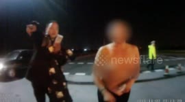 Driver takes her top off while being questioned by police