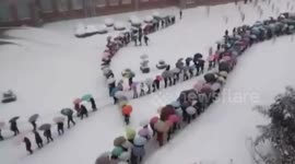 Aerial footage of hundreds of students walking home in the snow
