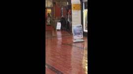 Man dances wildly outside electronics shop