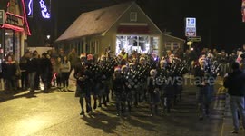 Ballater Winter Festival parade with LEDs on pipe band & children taking part