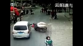Elderly woman is run over by minibus after knocked down by driverless tricycle