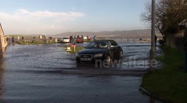 Cars driving through tidal surge flooding at Ulverston