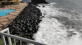 Tourist in the swimming pool almost caught by enormous wave