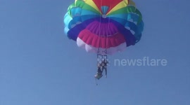 Woman hangs upside down metres above sea after parasailing accident