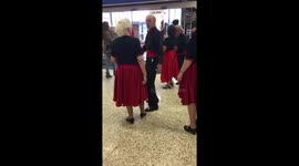 Baby utterly enthralled by singers in supermarket