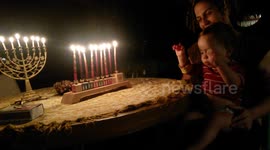 Hanukkah Mother and Baby Play Dreidel by Light of Menorahs