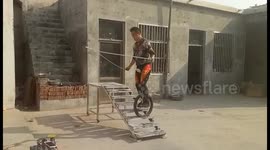 Man on unicycle skips rope to go up the stairs