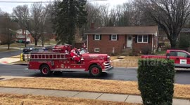 Santa parades through Maryland neighbourhood on an antique fire truck