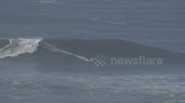 Pro surfer on XXL wave at Nazare Portugal