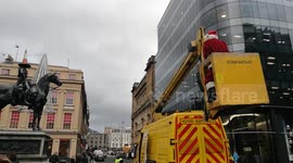 Bad santa leaves onlookers baffled by climbing iconic statue