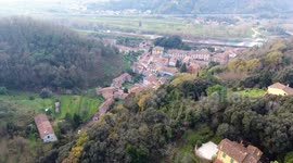 Aerial shot, a small town in the middle of the fall nature in Italy, Tuscany, filmed with drone
