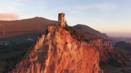 Aerial shot, Upezzinghi tower on the rocky outcrop in Italy, Tuscany, on the sunset light, filmed with drone