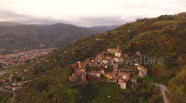 Aerial shot, gorgeous small village on the hill flyover, in middle of the fall colors, filmed with drone