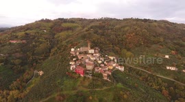 Aerial shot, gorgeous small village on the hill flyover, in middle of the fall colors, filmed with drone