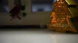 Video of a woman putting down a Christmas candle, selective focus