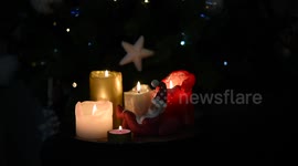 Video of beautiful lighted Christmas candles and a tiny sleeping Santa statuette
