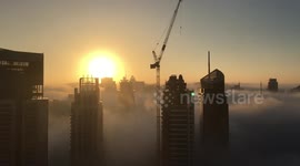 Dubai skyscrapers rise through thick fog