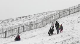 People enjoy sledding on the snow in Glenshee, Scotland