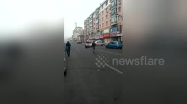 Newsflare Edit - Woman drove vehicle to shove police car after caught vandalizing shop windows on street in northern china
