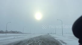 Snow blown on road creates wave-like patterns