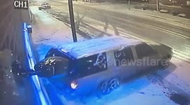Car drifting on icy road narrowly avoids street pole and building