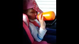 Funny cute toddler falls asleep in car while drinking