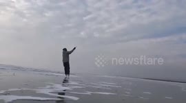 Men enjoy amazing views while 'ice-kiting' on frozen lake