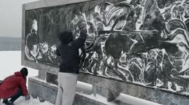 Women use snow to enhance embossed ancient Greek sculpture