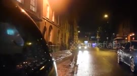 Man on skis is towed by a car through streets