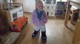 Funny baby wearing and walking in his daddies trainers.