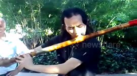 Artist plays music on gigantic flute