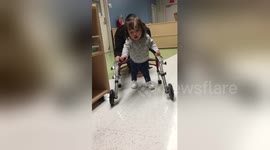 Baby with Down's syndrome learns to walk with special frame